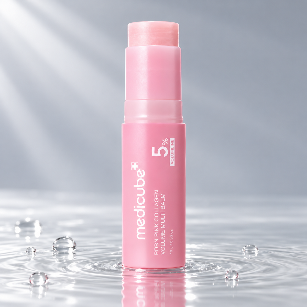 Medicube PDRN Pink Collagen Volume Multi Balm stick standing in clear water on a light grey studio background
