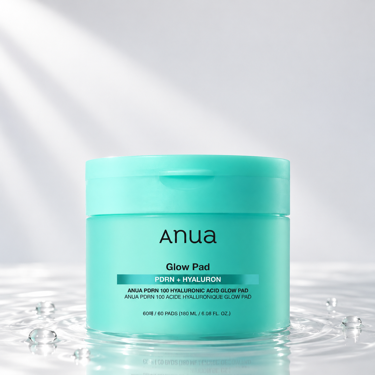 Anua PDRN Hyaluron Glow Pad jar standing in clear water on a light studio background