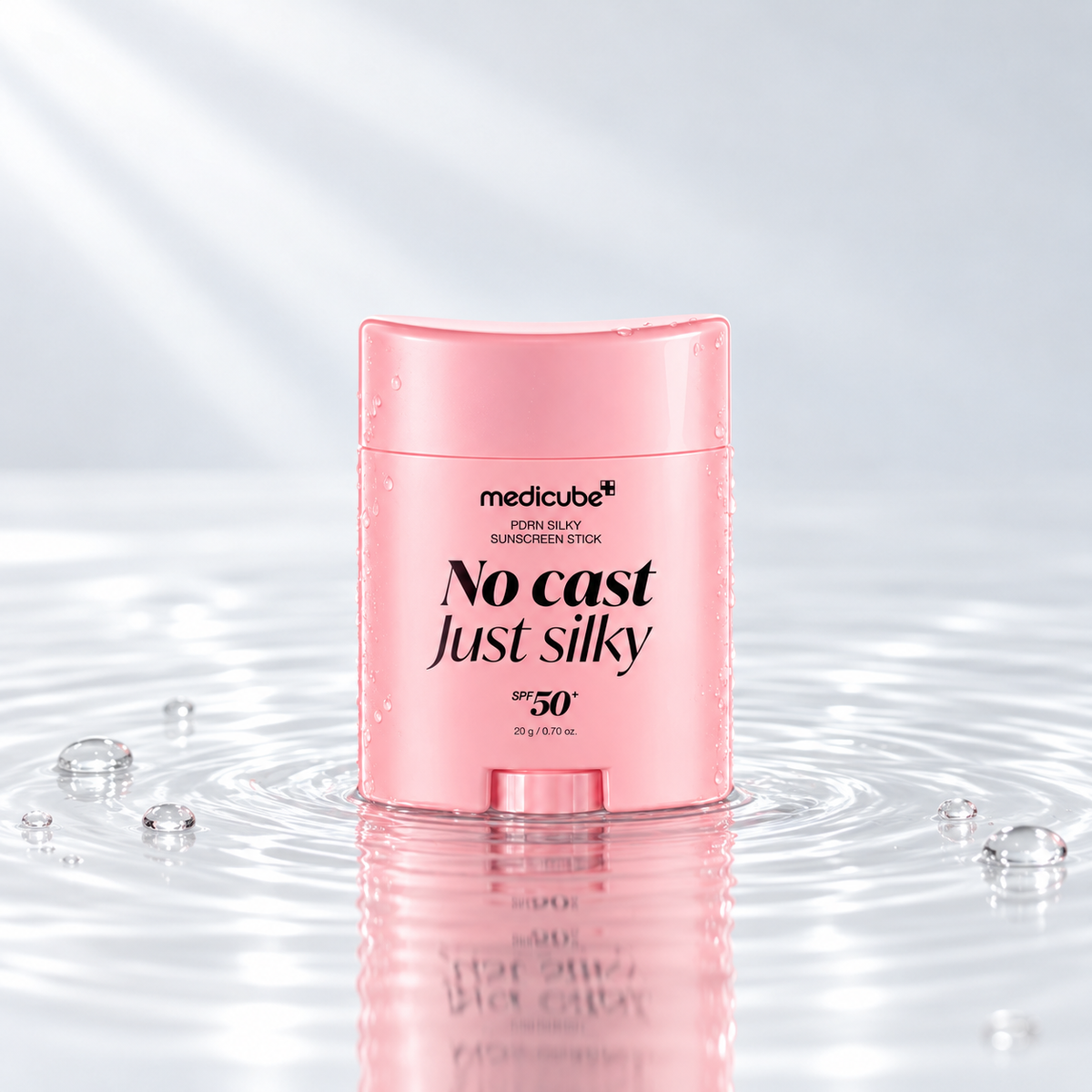 Medicube PDRN Silky Sunscreen Stick SPF50+ standing in clear water on a light studio background